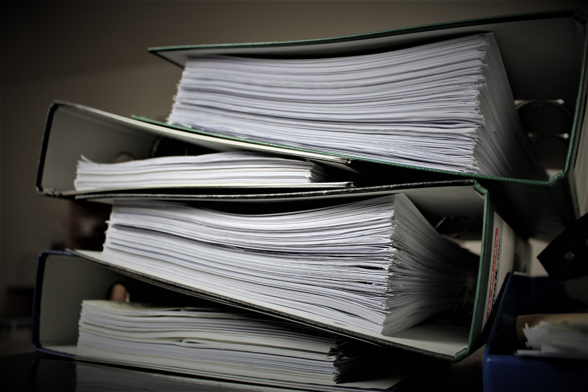 Stacks of paperwork in office binders, illustrating administrative bureaucracy
